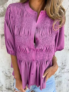 Detail of purple smocked blouse with front buttons and elegant bubble sleeves
