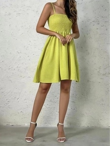 Detail of lime green smocked sundress with thin straps and a ruffled A-line hem