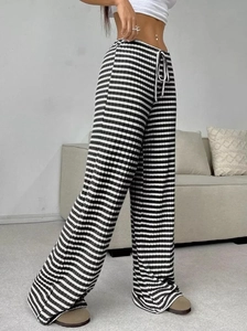 Detail of black and white striped knit texture on wide-leg trousers with drawstring