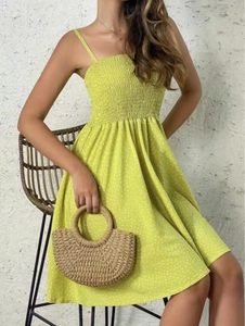 Detailed view of the yellow polka dot dress showing smocking technique and thin straps