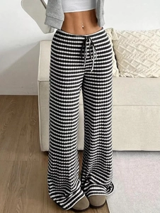 Close-up of high-waisted wide leg pants with ribbed texture and black drawstring waist