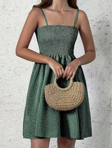 Detail of green polka dot summer dress featuring a smocked bodice and thin straps