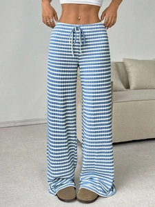 Detail of blue and white striped knit trousers with elastic drawstring waist texture