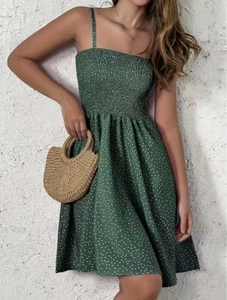 Close-up of smocked bodice and thin straps on dark green polka dot summer dress