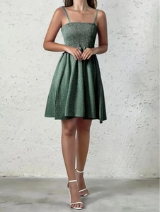 Detail of green polka dot summer beach dress with elastic waist and flared hem design