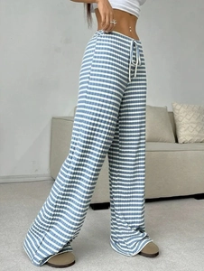 Detail of high waisted knit trousers featuring blue and white stripes and waist drawstring