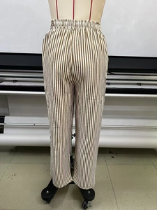 Detail view of elastic waistband on brown and white striped wide leg casual trousers