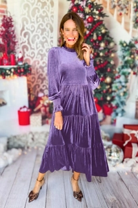 Dettaglio di elegante abito lungo in velluto con scollo a V, balze e maniche lunghe viola