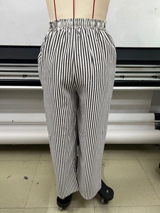 Detail of high-waist striped wide-leg trousers with elastic drawstring waistband