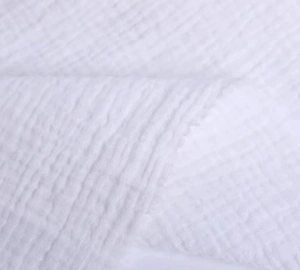 Close-up detail of white double layer cotton gauze fabric with breathable wavy texture