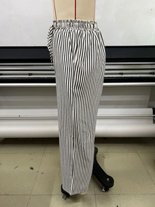 Detail view of adjustable drawstring elastic waistband on black and white striped wide leg pants