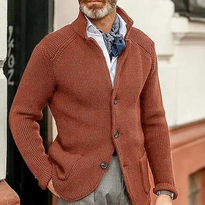 Detail of rust red waffle knit cardigan featuring stand collar and ribbed texture