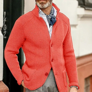 Detail of orange men's chunky waffle knit cardigan featuring high collar and button placket