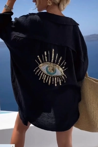 Close-up of black oversized shirt featuring a sequined evil eye embroidery on the back