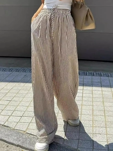 Detail of drawstring waist and pocket on striped wide-leg pants in natural outdoor light