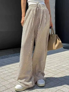 Detail of drawstring waistband on striped wide-leg pants for women in cream and black