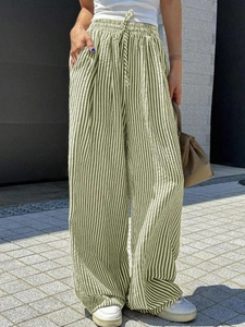 Detailed macro shot of green and white striped wide-leg pants with drawstring waist