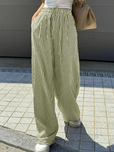 Detail view of high-waist striped wide-leg pants with adjustable drawstring and pockets