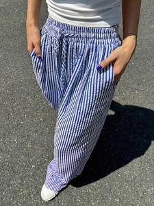 Detailed view of women's striped wide-leg pants with elastic drawstring waist and side pockets