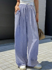 Detailed view of elastic drawstring waist on blue and white striped wide-leg trousers