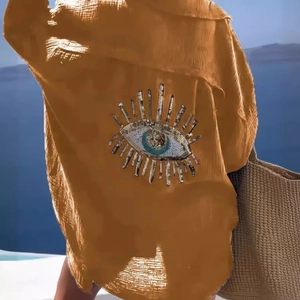 Mustard yellow button-down shirt featuring a sequined evil eye embroidery on the back