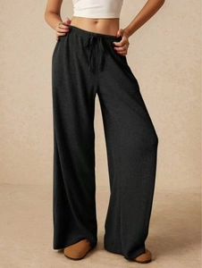 Vista dettagliata dei pantaloni larghi neri da donna con trama a costine e coulisse in vita
