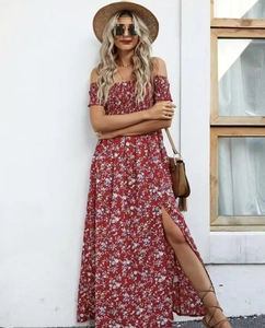 Detail van de off-shoulder halslijn en bloemenprint op de rode zomerse maxi-jurk