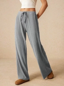Dettaglio dei pantaloni grigi a gamba larga con coulisse e tessuto a costine per donna