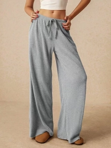 Dettaglio del tessuto a costine grigio chiaro e coulisse in vita sui pantaloni larghi