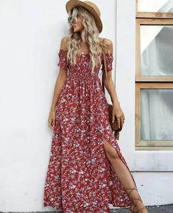 Detail van rode maxi-jurk met bloemenprint, blote schouders en een hoge zijsplit