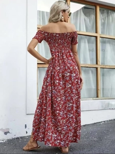 Detail van gesmokt off-shoulder lijfje en bloemenprint op een rode zomerse maxi-jurk