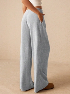 Dettaglio dei pantaloni grigi a gamba larga che mostra il tessuto e le tasche laterali
