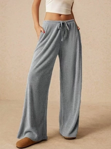 Dettaglio dei pantaloni grigi a gamba larga testurizzati con coulisse e tasche laterali