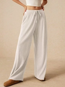 Dettaglio della trama a costine e della coulisse in vita sui pantaloni a gamba larga