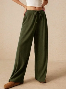 Dettaglio dei pantaloni a gamba larga verde scuro con trama in velluto a coste fitte