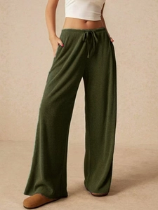 Dettaglio dei pantaloni a gamba larga verde oliva strutturati con vita con coulisse