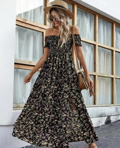 Detail van de gesmokte top en bloemenprint op deze bohemian jurk met blote schouders