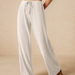 Pantaloni da donna a gamba larga color crema con trama a coste e coulisse in vita