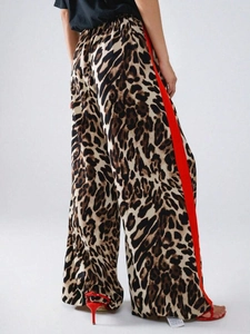 Detailansicht der Leoparden-Hose mit weitem Bein und markanten roten Seitenstreifen