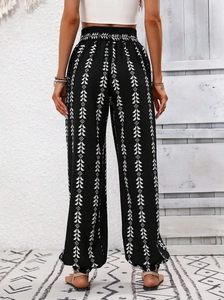 Detail of bohemian smocked waist and black geometric floral print harem pants