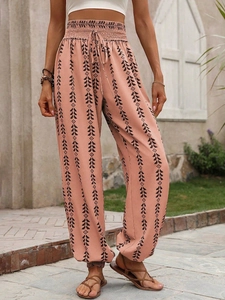 Close-up of bohemian high-waisted printed trousers with ethnic patterns and drawstring