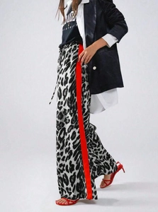 Detail der Leoparden-Hose mit weitem Bein, roten Kontraststreifen an der Seite und Kordelzug