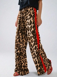 Detail der Damen-Leopardenhose mit weitem Bein und markanten roten Seitenstreifen