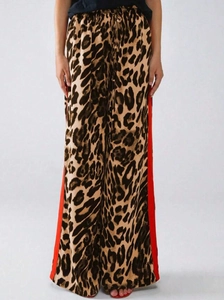 Detail der lockeren Leopardenhose mit roten Seitenstreifen und Kordelzug am Bund