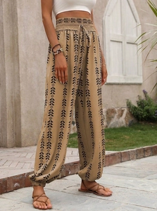 Close-up of bohemian high-waisted harem pants featuring geometric prints and tassel drawstrings