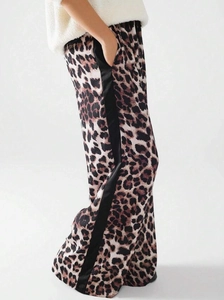 Detailansicht der weiten Hose mit Leopardenmuster, schwarzen Seitenstreifen und Gummizug