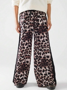 Detail der Leoparden-Print-Hose mit weitem Bein, schwarzen Seitenstreifen und Kordelzug