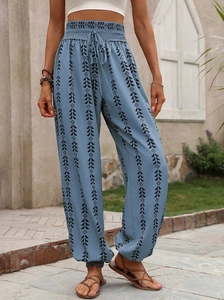 Detail of high waisted bohemian jogger pants with blue ethnic floral geometric print