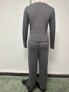 Vista posteriore di un set maglia a maniche lunghe e pantaloni larghi grigio scuro su manichino