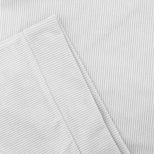 Dettaglio macro della trama in maglia a coste grigio chiaro su colletto e polsini